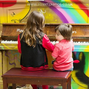 Kids playing on a Play me I'm yours street piano, St Pancras
